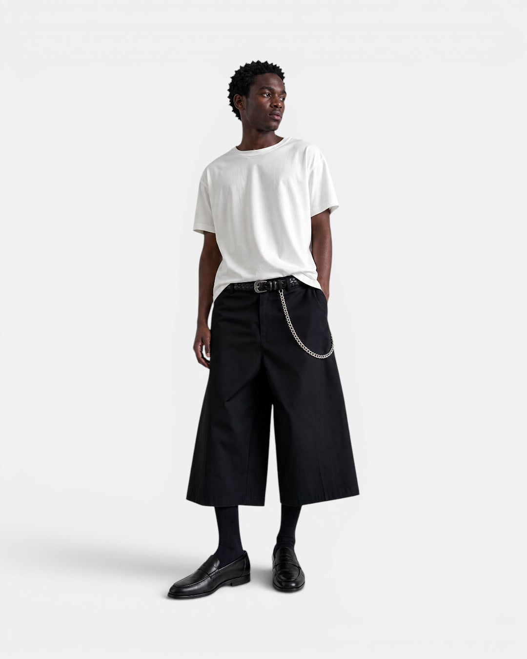 NAMELESS black A-line blazer shorts with a silver chain detail and a braided belt, worn by a man with a white t-shirt.