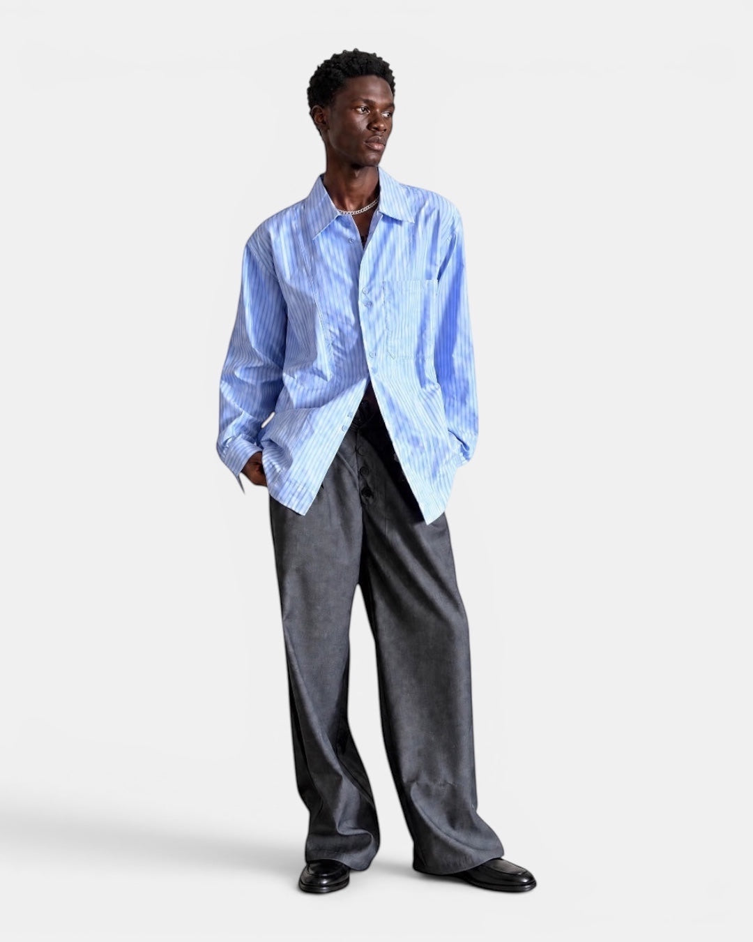 Nameless light blue and white striped long-sleeved collared shirt with a loose fit, worn by a male model.