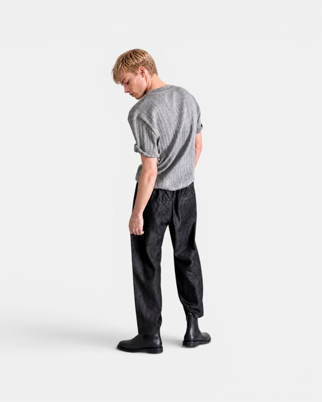NAMELESS grey textured short-sleeved knitted top with cuffed sleeves, worn by a male model with black trousers.
