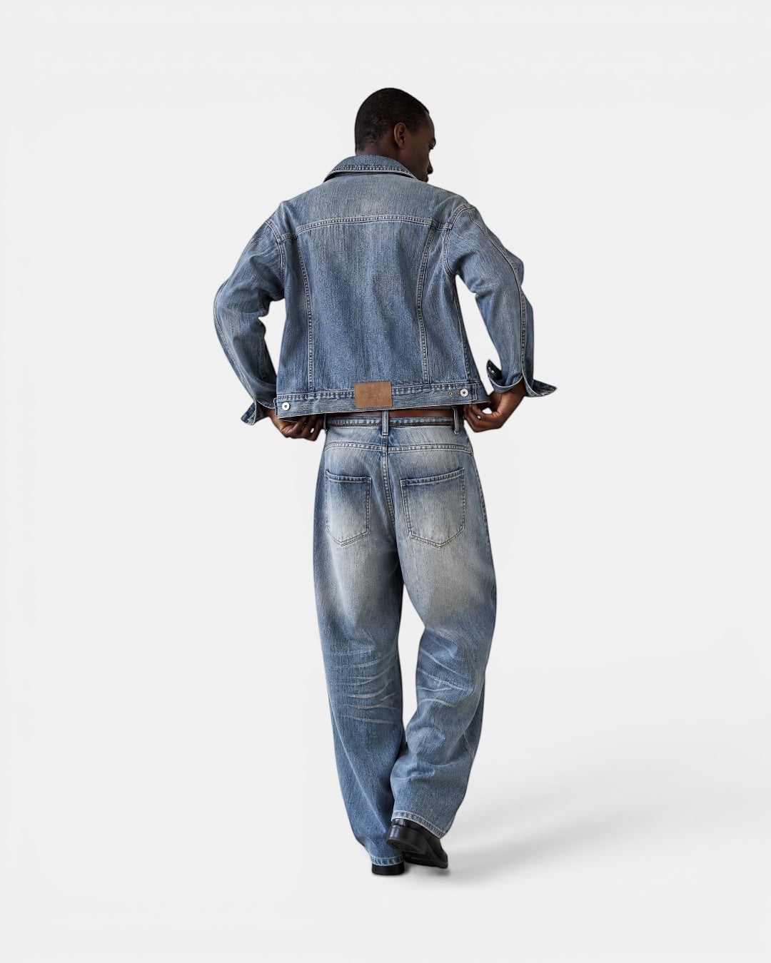 NAMELESS light wash distressed denim jeans with a wide-leg silhouette and authentic fading. Model shown from back.