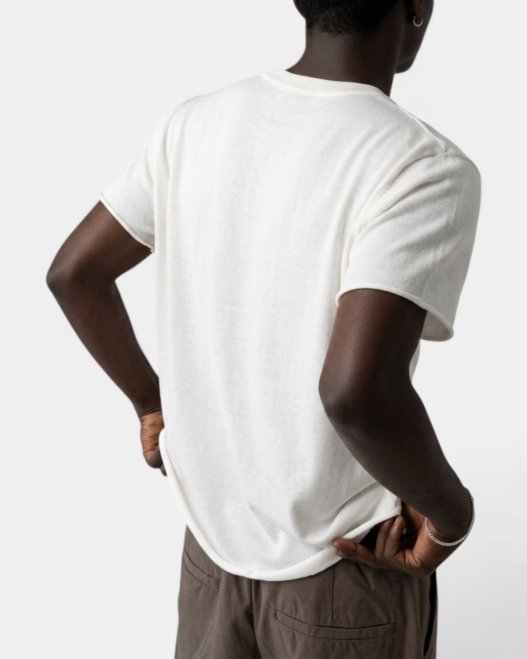 NAMELESS off-white short-sleeve knit top with cuffed sleeves and a relaxed fit, worn by a man.