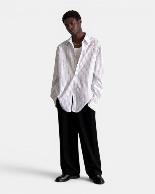 NAMELESS white long-sleeved shirt with subtle blue pinstripes, worn by a male model with black trousers.