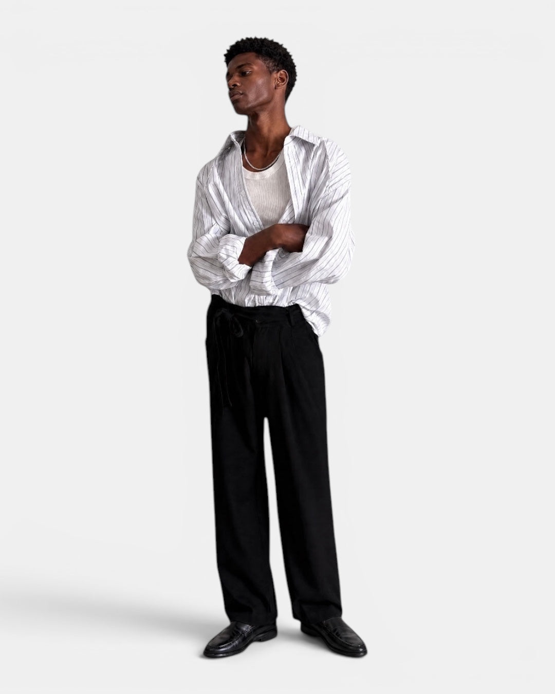 NAMELESS white and blue pinstriped long-sleeved cotton shirt worn by a man with arms crossed.
