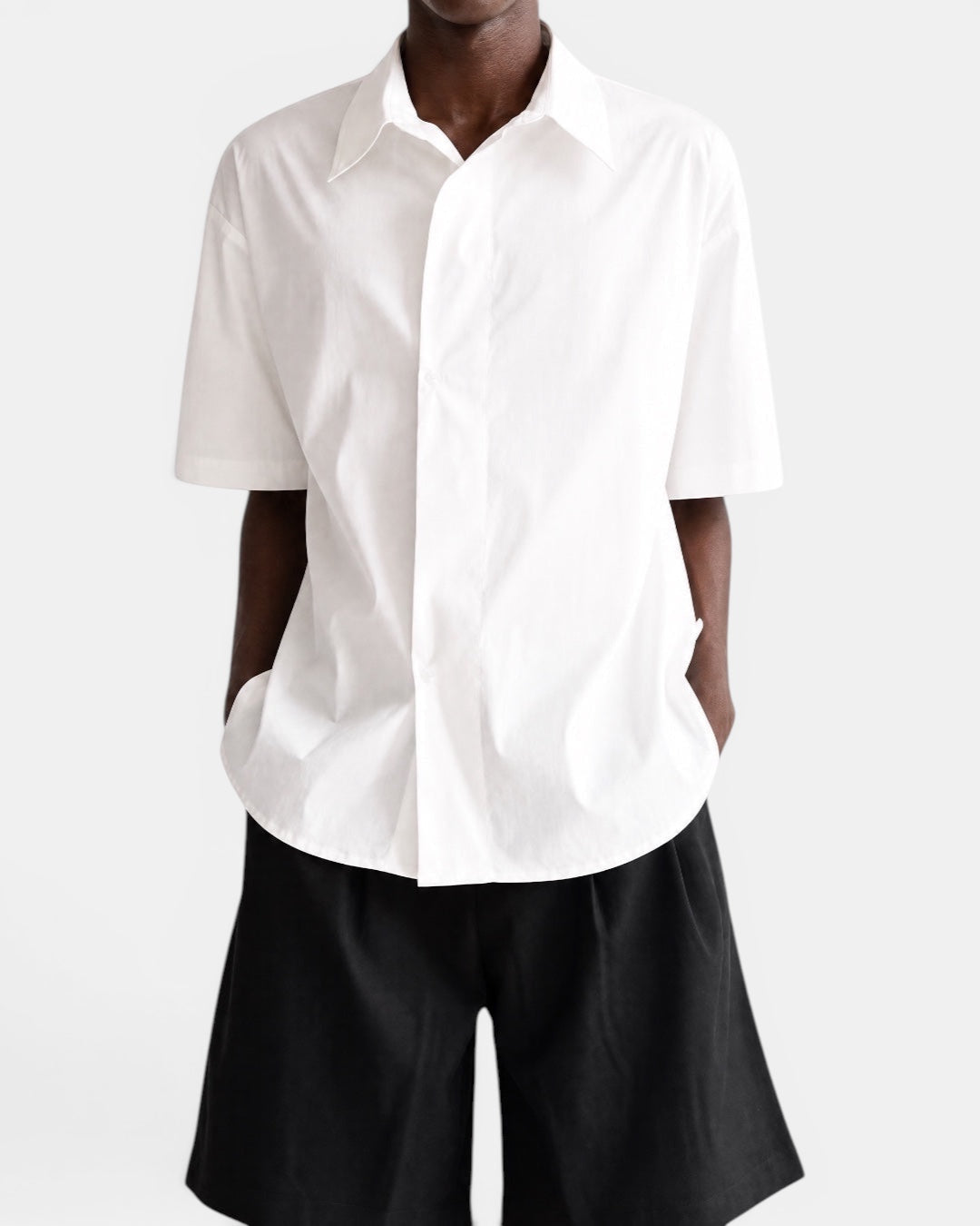 Nameless white cotton short-sleeved shirt with pointed collar and slanted placket, worn by a man.