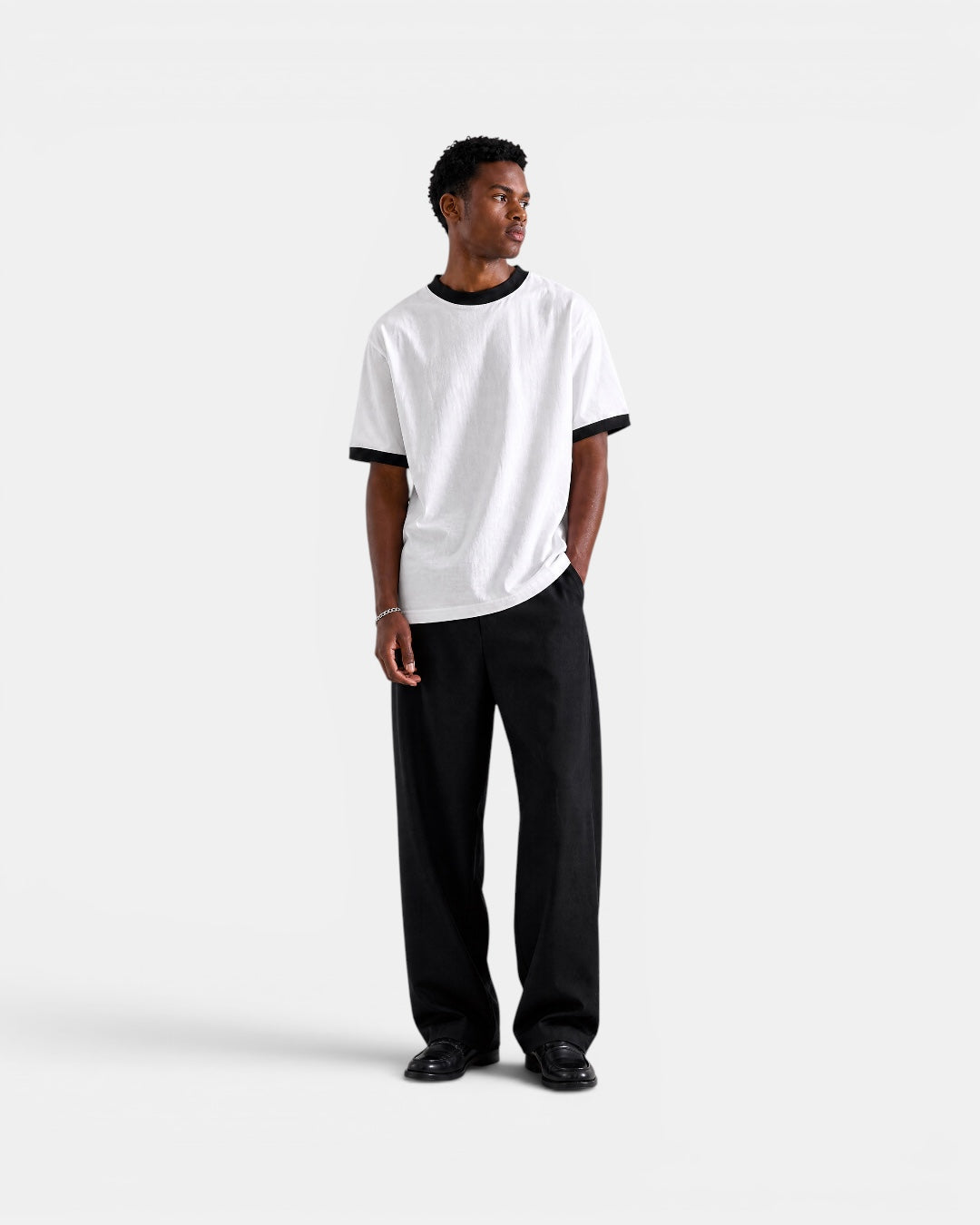 NAMELESS white cotton t-shirt with black trim on collar and sleeves, worn by a man.