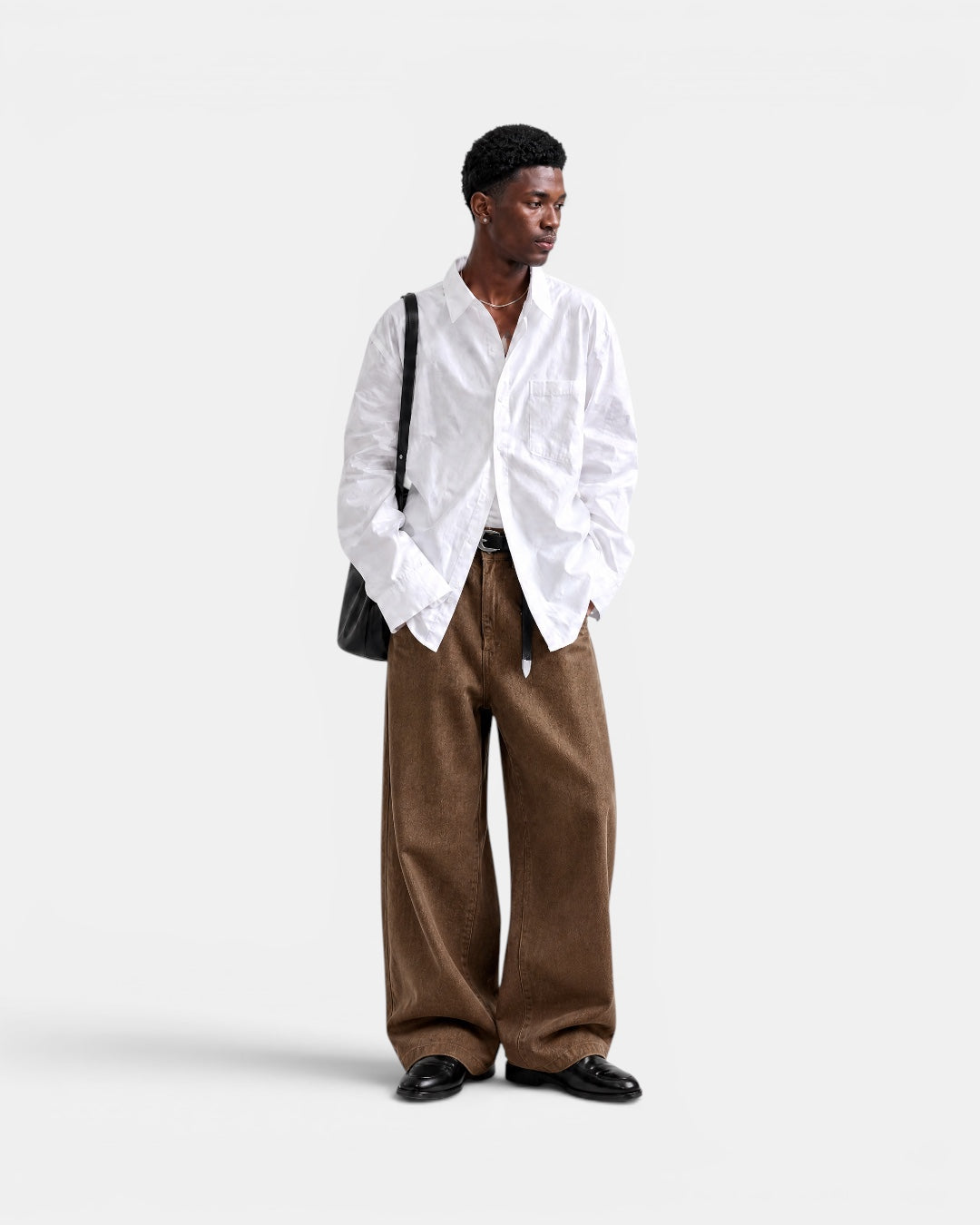 Nameless white solid-color long-sleeved oversized cotton shirt worn by a man with brown wide-leg pants.