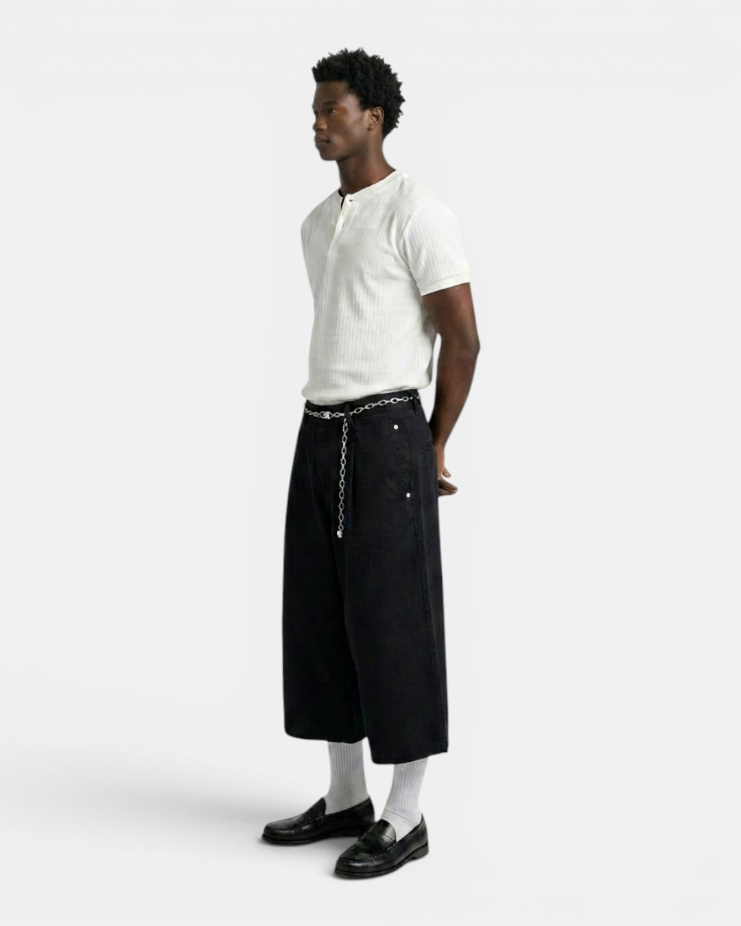 NAMELESS white ribbed henley t-shirt with short sleeves and a buttoned neckline, paired with black wide-leg pants.