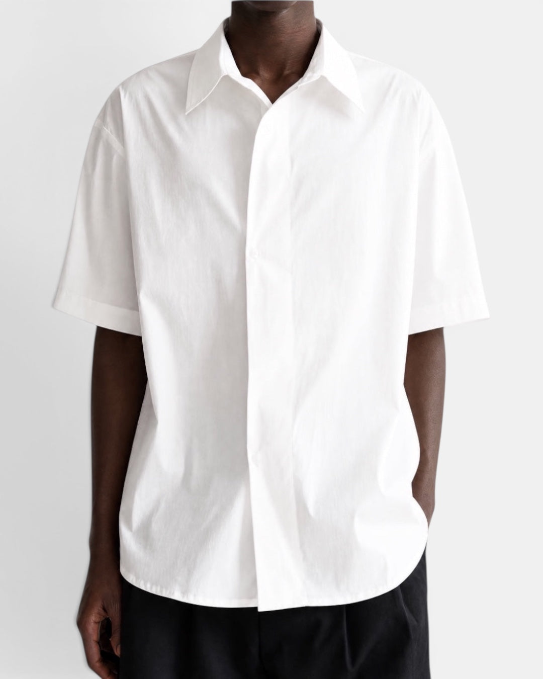 Nameless white short-sleeved cotton shirt with pointed collar and slanted placket, worn by a man.