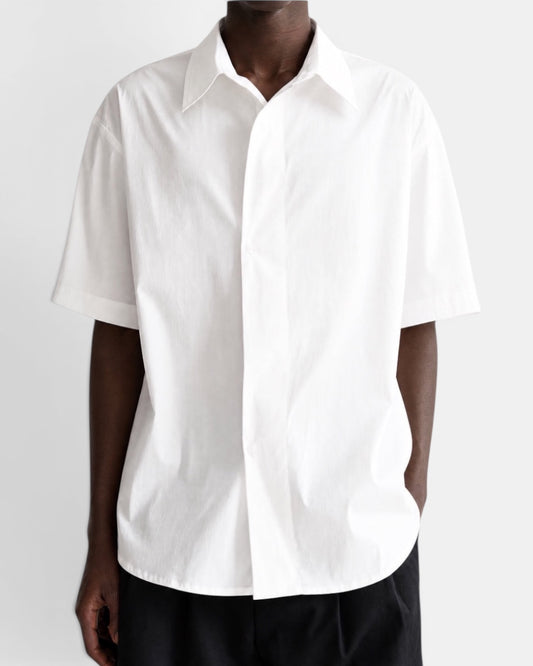 Nameless white short-sleeved cotton shirt with pointed collar and slanted placket, worn by a man.